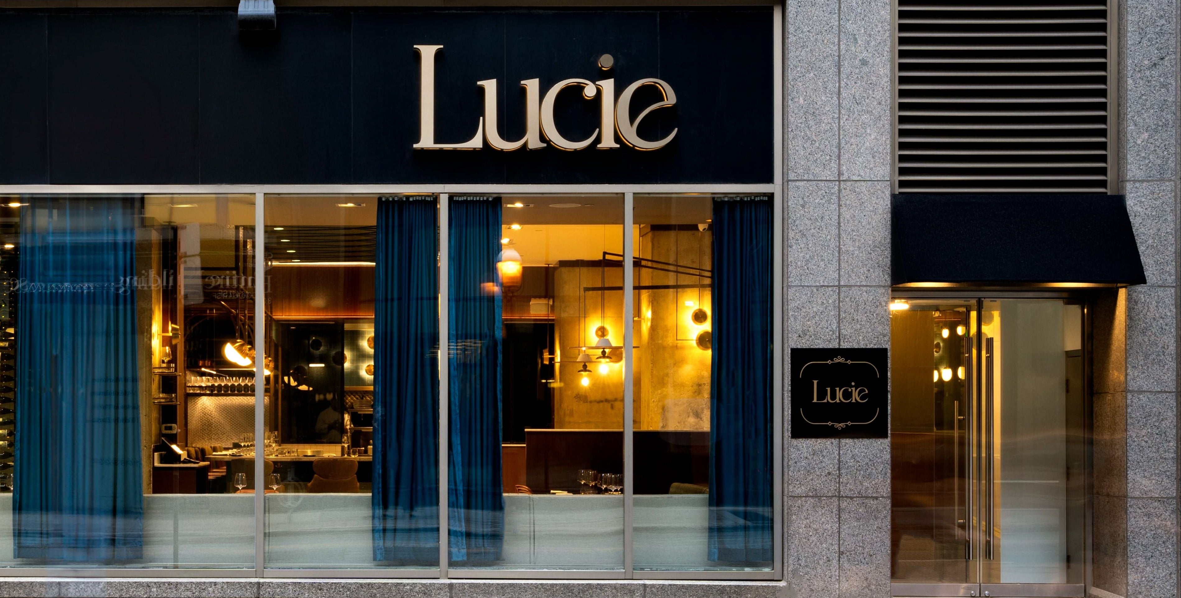 Storefront with 'Lucie' sign on a building facade